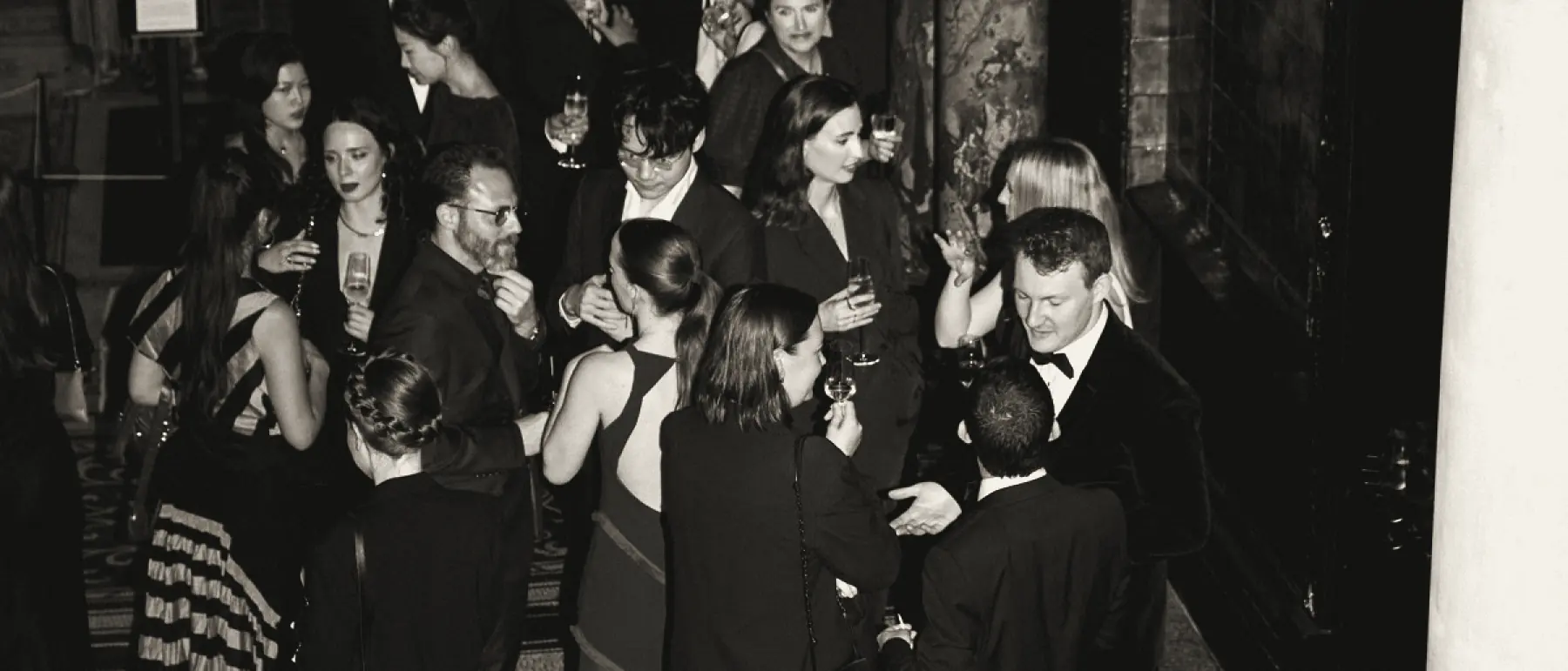 Guests in conversation on the staircase landing at Leighton House, London