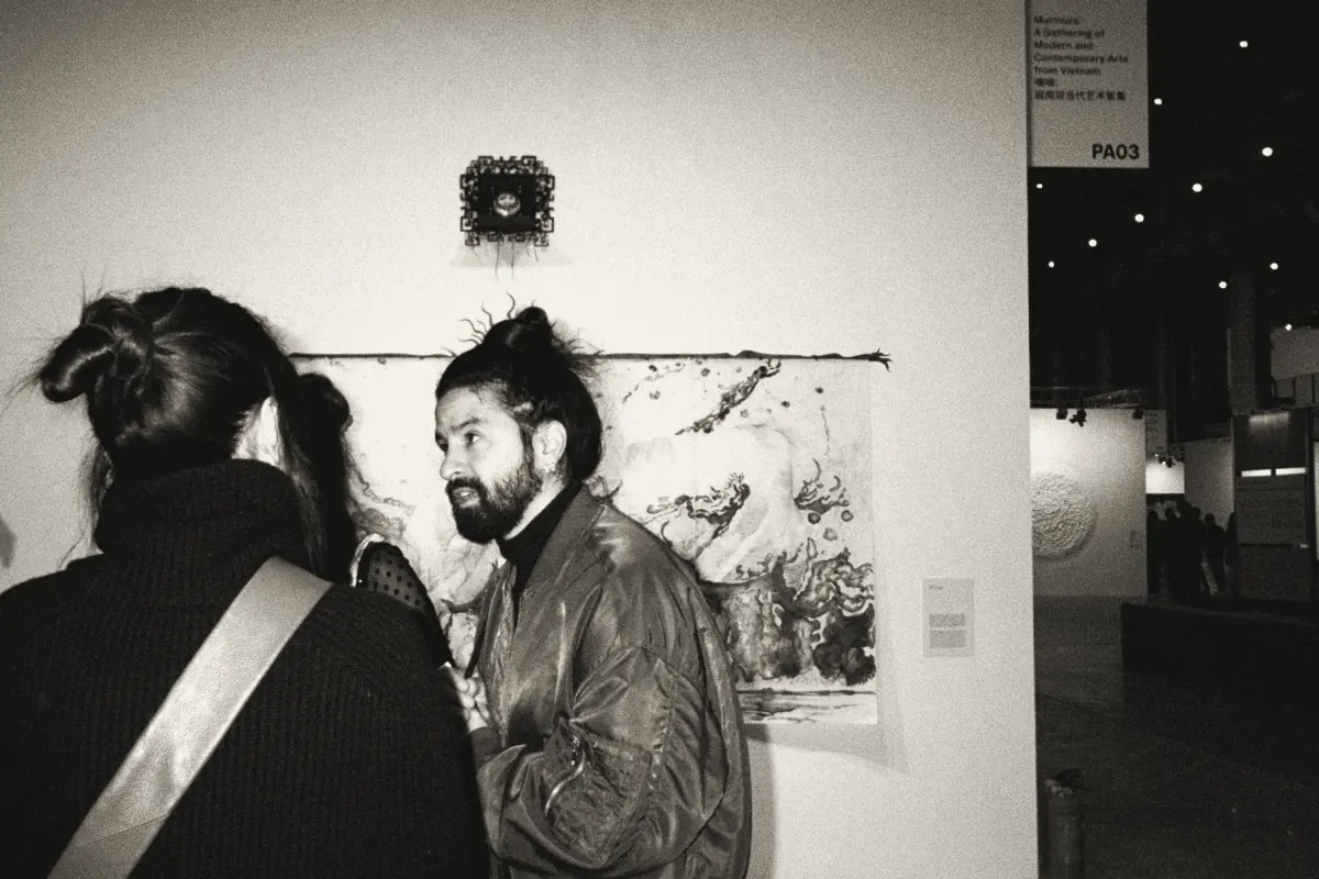 Two visitors in conversation in front of a painting at West Bund Art & Design, Shanghai